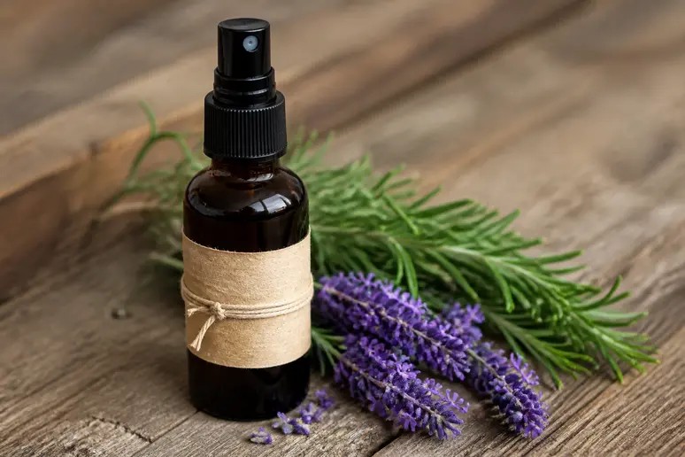 Spray anti moustique naturel maison et ses ingrédients naturels sur une table en bois.
