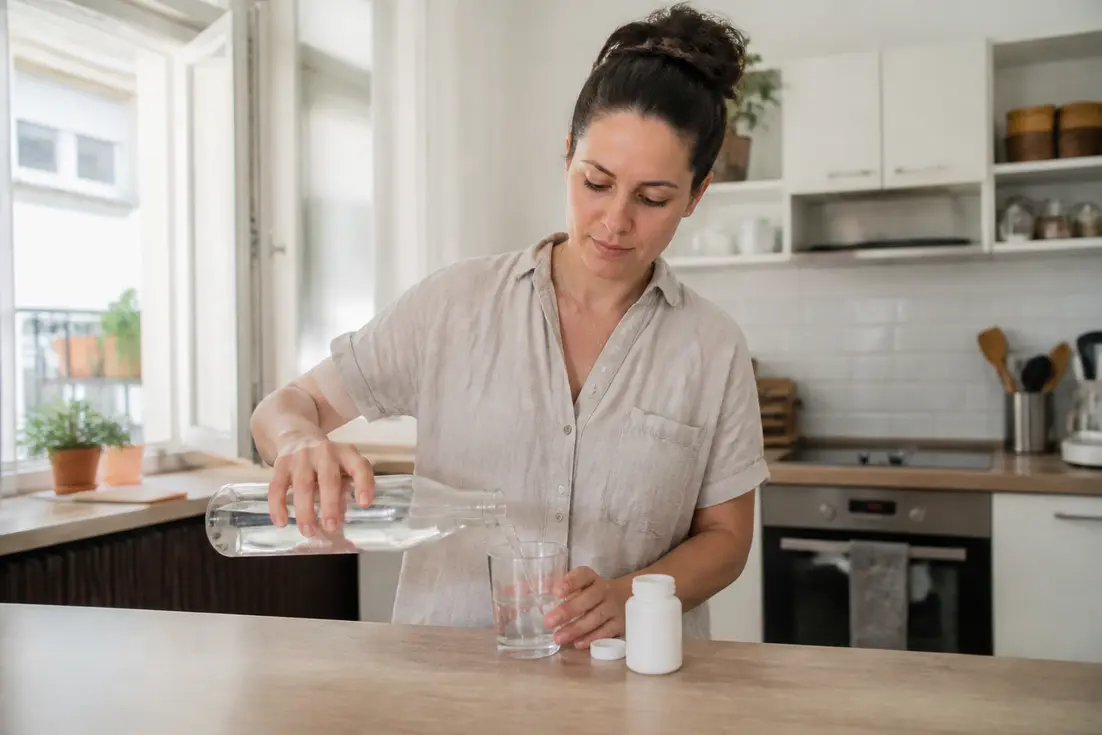 Une personne prépare un verre d'eau en cuisine pour sa cure Epycure perte de poids avis au quotidien