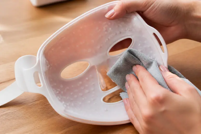 Nettoyage minutieux du masque LED Current Body avec un chiffon doux après la séance
